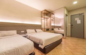 een hotelkamer met 2 bedden en een spiegel bij Bpod at Setapak KL in Kuala Lumpur