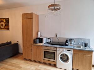 a kitchen with a washing machine and a microwave at Maestria Apartament 1 in Sulechów