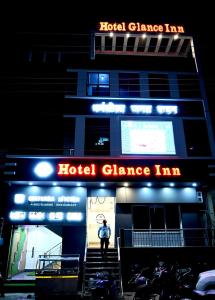 een persoon die voor een hotel dansherberg staat bij Hotel Glance Inn in Gulzārbāgh