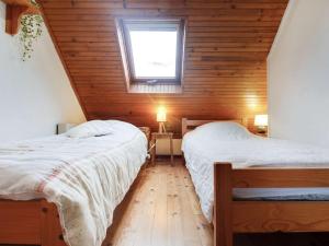 two beds in a room with wooden walls and a window at Appartement Viella - Hautes-Pyrénées, 2 pièces, 4 personnes - FR-1-402-48 in Viella