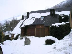 a house covered in snow with a garage at Appartement Viella - Hautes-Pyrénées, 2 pièces, 4 personnes - FR-1-402-48 in Viella