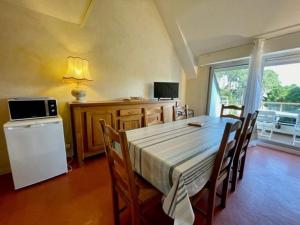 a dining room with a table with chairs and a window at Appartement Quiberon, 3 pièces, 5 personnes - FR-1-478-75 in Quiberon