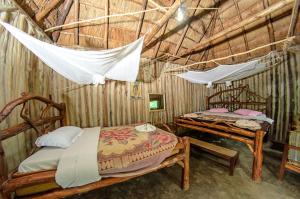 a bedroom with two beds in a straw hut at Dave the Cave Eco Lodge and Cultural Campsite in Rubirizi