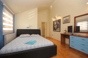 a bedroom with a bed and a desk with a computer at Villa Dragana in Budva