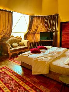 Princess luxury camp في وادي رم: غرفة نوم بسرير كبير وأريكة