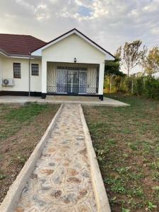 una casa con una pasarela frente a un patio en Villa (9) Del Sol: 1 bedroom, a patio & Lakefront en Kisumu