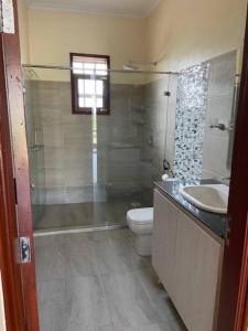 y baño con aseo, lavabo y ducha. en Villa (9) Del Sol: 1 bedroom, a patio & Lakefront en Kisumu
