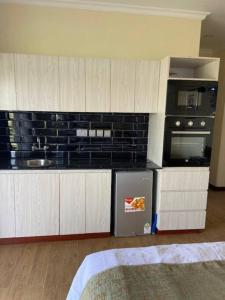 cocina con fregadero y microondas en Villa (9) Del Sol: 1 bedroom, a patio & Lakefront en Kisumu