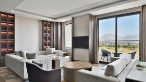 a living room with a couch and chairs and a table at JW Marriott Hotel Bengaluru Prestige Golfshire Resort & Spa in Bangalore