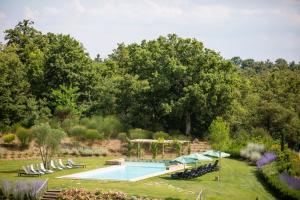 uma piscina no meio de um jardim em Luxury Resort with swimming pool in the Tuscan countryside, apartments with private outdoor area with panoramic view em Osteria Delle Noci