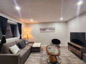a living room with a couch and a flat screen tv at Comfort First - sleeps 6 in Whitehorse