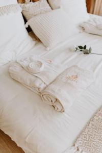 - un lit blanc avec des serviettes et des fleurs blanches dans l'établissement Chambre Riposo, à Tubize