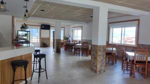 ein Esszimmer mit Tischen, Stühlen und Fenstern in der Unterkunft Jumboli in Redondela
