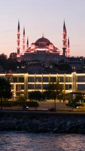 a large building with a mosque in the background at Kalyon Hotel Istanbul in Istanbul