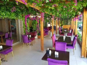 a restaurant with purple chairs and tables and flowers at Gardan Hotel in Beylikduzu