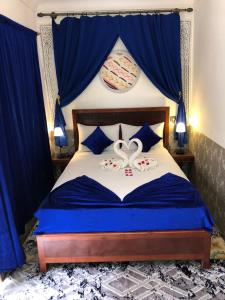 a bedroom with a blue bed with two swans on it at Riad Lazorde De Marrakech in Marrakesh