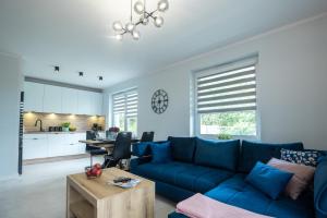 un soggiorno con divano blu e una cucina di Apartament LUX Rakownica a Jelenia Góra