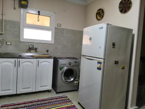 a kitchen with a refrigerator and a washing machine at للسيدات Master bedroom for ladies only Sheik Zayed in Sheikh Zayed