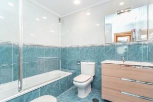 a bathroom with a toilet and a tub and a sink at Apartamento con garaje in Luanco