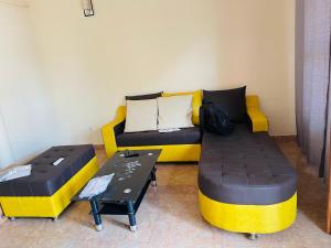 a living room with two beds and a couch at Villa contemporaine in Yaoundé