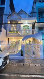 Casa blanca con puerta y balcón en HaHe Homestay en Dalat