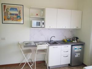 cocina con armarios blancos y encimera en Ori Villa Oriana, en Baveno
