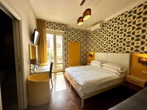 Un dormitorio con una cama y una pared con platos. en Pellicano Guest House en Reggio Calabria