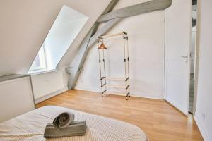 a attic bedroom with a ladder and a bed at Le Bel-Air AVALLON in Avallon