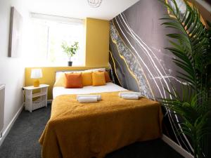 a bedroom with a bed with yellow and orange pillows at Open Mind Property - Luxury Apartment in the City in Portsmouth