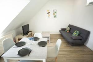 a living room with a table and a couch at Le Bel-Air AVALLON in Avallon