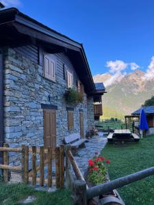 una casa de piedra con una valla y flores delante de ella en Casa Prabellino, en Caspoggio