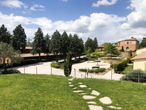 um jardim com um caminho na relva em Luxury Resort with swimming pool in the Tuscan countryside, apartments with private outdoor area with panoramic view em Osteria Delle Noci