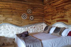 uma cama num quarto com uma parede de madeira em Alma Villa 2 - Lovely 1 Bedroom with Pool em Uluwatu