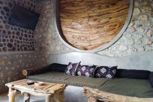uma sala de estar com um sofá e uma mesa de madeira em Alma Villa 2 - Lovely 1 Bedroom with Pool em Uluwatu