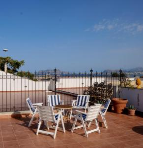 un patio con tavolo, sedie e spiaggia di Attico con terrazza sul porto a Palermo