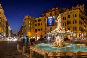 a fountain in the middle of a city at night at Suite Artis Barberini in Rome