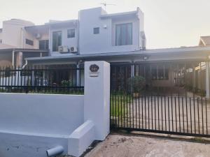 een wit huis met een hek en een hek bij Pool Villa Melaka up to 18 pax in Melaka