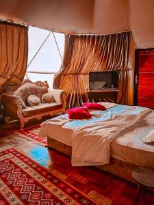 a bedroom with a large bed and a piano at Princess luxury camp in Wadi Rum
