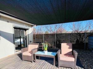 a patio with two chairs and a table on a deck at Twin Room -2single beds in share house in Queanbeyan & Canberra in Queanbeyan