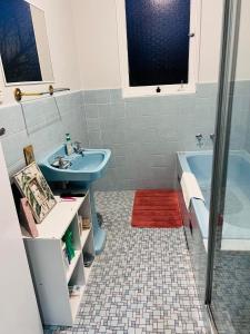 y baño con lavabo azul y bañera. en Twin Room -2single beds in share house in Queanbeyan & Canberra en Queanbeyan