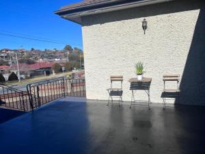 a patio with three chairs and a table with a plant on it at Twin Room -2single beds in share house in Queanbeyan & Canberra in Queanbeyan