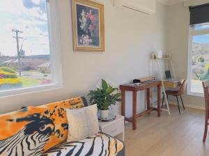 sala de estar con sofá y escritorio en Twin Room -2single beds in share house in Queanbeyan & Canberra en Queanbeyan