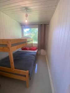 Stugan في Lemland: غرفة صغيرة مع سريرين بطابقين ونافذة