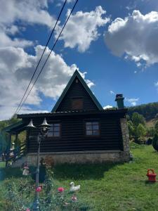 a wooden house with a blue sky and clouds at Odmor in Šavnik