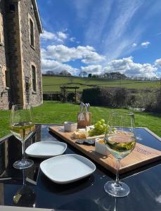 een tafel met twee glazen witte wijn erop bij Tegfan Garden Suite in Talgarth