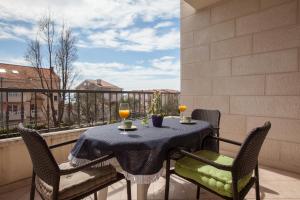 uma mesa numa varanda com dois copos de vinho em Apartments Tino em Makarska