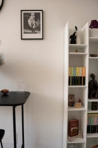 een kamer met een tafel en een boekenplank met boeken bij Fara's House in Napels