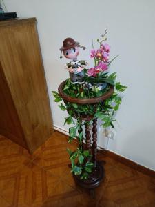 Un vaso con fiori e la statua di un uomo di Apartamento Boca Doce a Ponta Delgada