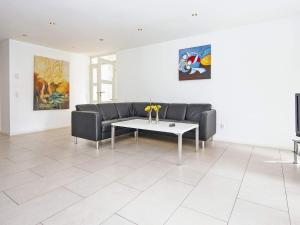 a living room with a couch and a table at 14 person holiday home in Grenaa in Grenå