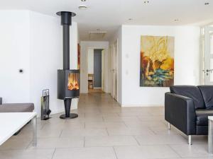 a living room with a fireplace and a couch at 14 person holiday home in Grenaa in Grenå